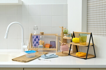 A kitchen sink in a typical home, with various kitchen utensils placed on it	