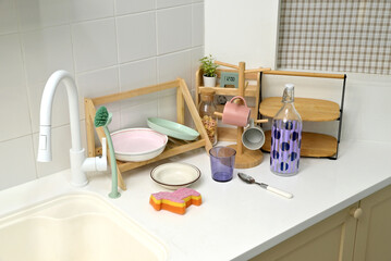 A kitchen sink in a typical home, with various kitchen utensils placed on it	
