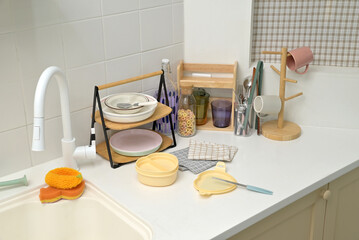 A kitchen sink in a typical home, with various kitchen utensils placed on it	
