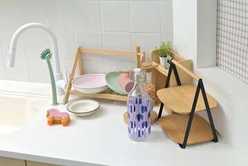 A kitchen sink in a typical home, with various kitchen utensils placed on it