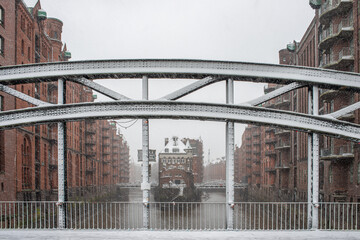 Fototapeta premium Die Speicherstadt in Hamburg mit dichtem Schneefall mit Schneeflocken in der Luft im WInter