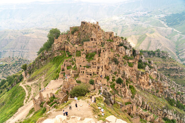 Obraz premium Dagestan Gamsutl. Ancient ghost town of Gamsutl old stone houses in abandoned Gamsutl mountain village in Dagestan, Abandoned etnic aul, summer landscape.