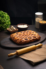 Curd pie on a fluffy ruddy dough on a dark wooden table