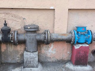 Old blue metallic water meter. Pipe for water piping system. Water consumption concept