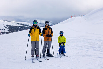 Happy family with kids in winter ski resort, skiing winter time