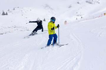 Happy family with kids in winter ski resort, skiing winter time
