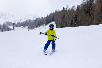 Happy family with kids in winter ski resort, skiing winter time