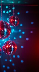 Obraz premium Shiny red disco balls hanging against dark blue background with glowing bokeh lights. Retro nightclub atmosphere for party decoration, entertainment events and celebrations