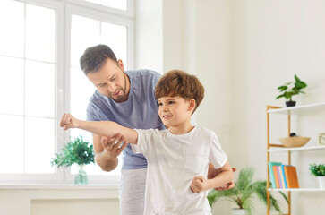 Family sport fun, father and young son learn boxing, fighting with fists, healthy happy fitness emotion. Parent, child boy spend holiday in sport, enjoy weekend time together, good relationships