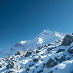 Snow capped mountain peak on a sunny day, blue sky.