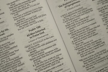 Obraz premium An open Bible displays Psalm 100, calling all men to praise God joyfully