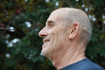Naklejka premium Elderly Man Smiles Talking With His Friend In The Natural Park