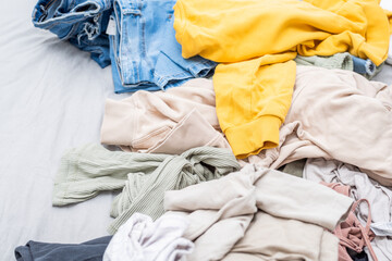 Clothes are haphazardly scattered on the bed