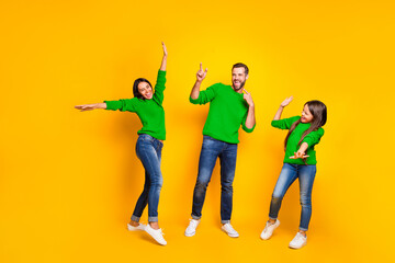Full length body size photo of cheerful crazy ecstatic overjoyed family with people dancing at club together wearing jeans denim sneakers isolated over vivid color yellow background