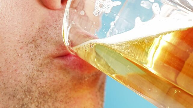 Close-up. A man with stubble drinks beer. A cold refreshing drink.
