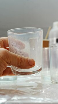 vertical video. wash glass glasses with wooden lids for candle making. Hand-made natural candles.