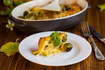cauliflower and brussel sprouts casserole with cheese, in a plate on a wooden table