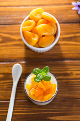 Light fruit yogurt with dried apricots on dark wooden table
