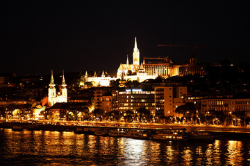 A beautiful city illuminated at night featuring a bridge in the foreground. Budapest