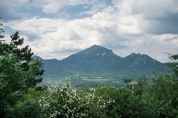 Fototapeta premium A landscape with a view of mountains covered with forest and a valley with a small settlement at the foot.