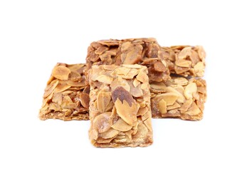 Pieces of almond crunch or almond brittle, traditional italian dessert, on white background.