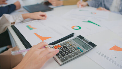Fototapeta premium Accountant using a calculator for financial statement tax analysis investment planning office meeting. women Leadership in financial analysis, collaboration in business strategy saving reports