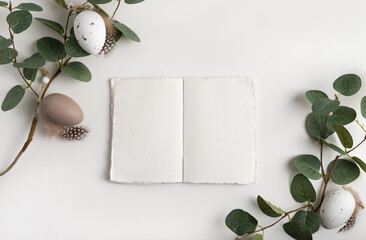 Open notebook , eucalyptus branches and decorative eggs. Easter background with copy space for your text.