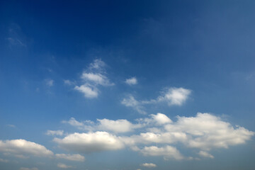 A bright blue sky with fluffy white clouds creating a serene and peaceful atmosphere