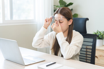 Eye problem concept, fatigue asian young woman tired eyes, irritated rubbing nose dry relief vision pain after work on laptop computer, eye strain, put glasses on table, suffer migraine, bad blurry.