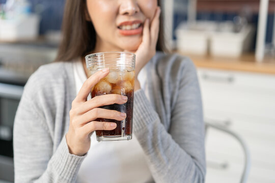 Health care asian young woman touching mouth, expression, girl suffering from toothache, decay or sensitivity cavity molar tooth or inflammation drink cold, sparkling water. Sensitive teeth people.