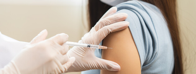 Fototapeta premium Health care, corona virus, hand of woman nurse, doctor giving syringe vaccine, injection dose on arm sick patient at clinic. Vaccination, immunization disease prevention against flu pandemic influenza