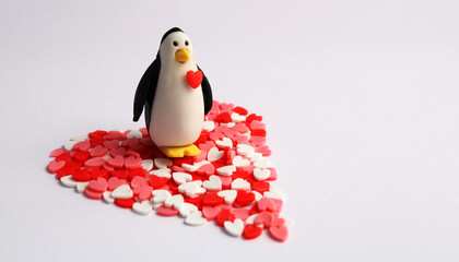Penguin with a heart in his chest standing on a big heart