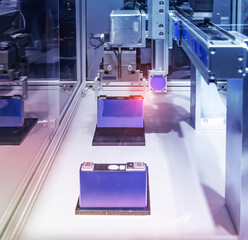 Industrial Robot Arms Assemble Lithium-Ion EV Battery Pack at Automated Production Line at Bright Modern Factory.  Electric Car Manufacturing Inside Automotive Smart Factory