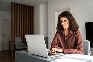 Young freelance business woman using laptop computer for online remote programmer work. Latin hispanic or middle eastern girl student watching webinar studying lesson. Businesswoman working remotely
