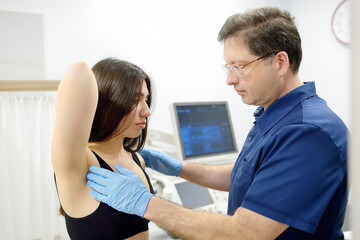 Obraz premium Doctor mammologist examines woman breasts and lymph nodes