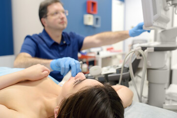 Mammologist doctor examines a woman breasts and lymph nodes using ultrasound. Mammography and...