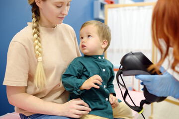 Toddler boy with mom are at appointment with a pediatric neurologist. Neurology doctor is...