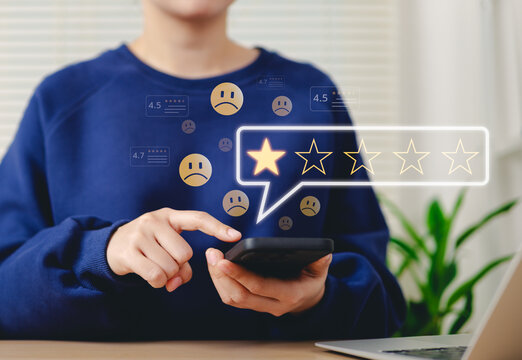 Negative customer review, online feedback concept. Woman using smartphone to leave one star review, with sad face emojis and rating icons. customer feedback, online reviews, consumer dissatisfaction,