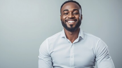 Obraz premium Confident Smiling Man Wearing White Shirt Expressing Happiness and Positivity