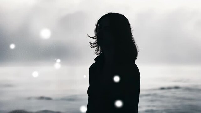 Woman silhouetted against stormy ocean, windswept hair, contemplative mood