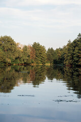 Beautiful summer lake, trees reflected in water, with calm lake surface