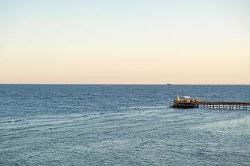 Obraz premium Calm waters and serene horizon at a waterfront pier in Egypt during early evening hours