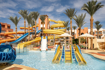 Vibrant water park in Egypt featuring colorful slides and palm trees on a sunny day