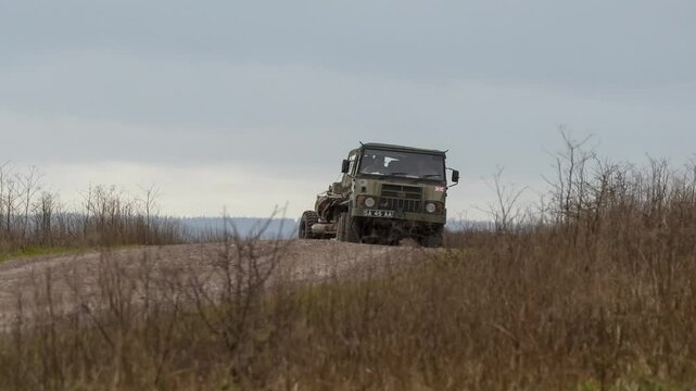 British army bae systems, Puch, Daimler, Pinzgauer High-Mobility All-Terrain 6x6 vehicle towing a 105mm Light Artillery Gun on a military exercise