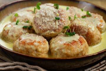 chicken meatballs, in cream sauce, garnished with parmesan cheese, and microgreens, homemade, no people,
