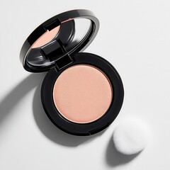 Compact blush on a white surface with a beauty applicator nearby, highlighting makeup essentials for a flawless look