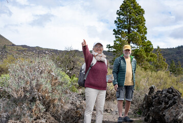 Carefree senior couple enjoying hiking day in mountain excursion expressing happiness and...