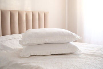  Two white pillows on bed morning light on pillows.