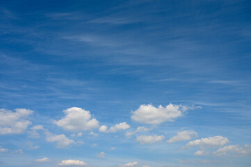 Expressions of serenity in a clear blue sky dotted with fluffy clouds at midday
