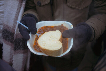 Piece of bread and stew in hands